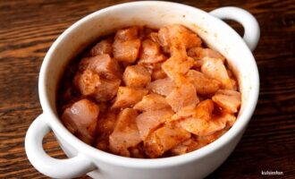 Куриная грудка, нарезанная кубиками, замаринованная с приправами и чесноком в миске