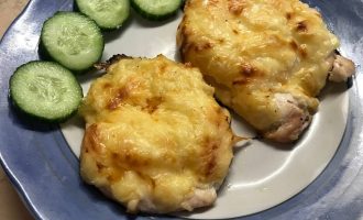 Готовые куриные отбивные с ананасом и сыром на тарелке с овощным гарниром