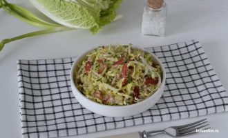 Салат с пекинской капустой, киноа, огурцами и помидорами в тарелке на столе
