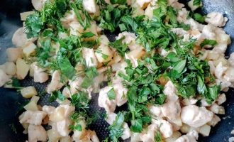 Обжаренные курица с картофелем и свежей зеленью в сковороде