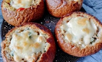 Закусочные булочки с картофельной начинкой, курицей и расплавленным сыром на тарелке