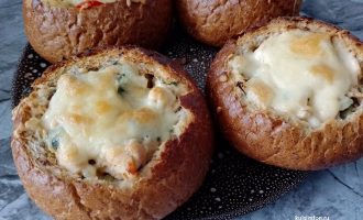 Готовые булочки с картофелем, курицей и расплавленным сыром на тарелке