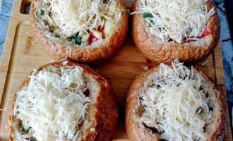 Булочки с начинкой, посыпанные тертым сыром, перед запеканием