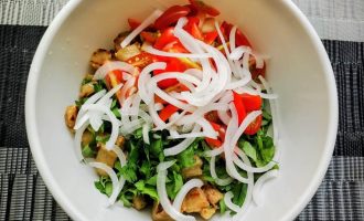 Салат в миске с луком, зеленью, сыром и баклажанами