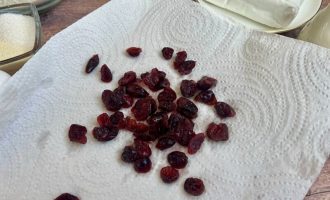 Размоченная клюква на бумажном полотенце после слива воды