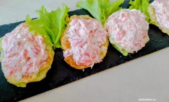 Кабачковые оладьи с творожным сыром и слабосоленой кетой, украшенные зеленью на тарелке