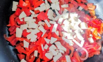 Лук и помидоры обжариваются на сковороде для болгарского омлета