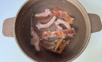 Ребра варятся в кастрюле для бульона с горохом