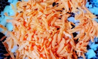 атертая морковь и нарезанный лук на сковороде для обжарки овощей