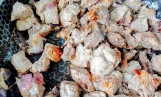 Обжаренные кусочки свинины с луком на сковороде