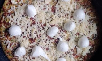 Посыпание лепешки твердым сыром и добавление моцареллы.