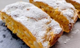 Яблочно-морковный кекс, посыпанный сахарной пудрой, нарезанный на кусочки.