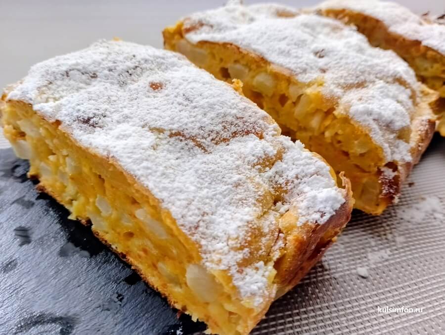 Яблочно-морковный кекс, посыпанный сахарной пудрой, нарезанный на кусочки.
