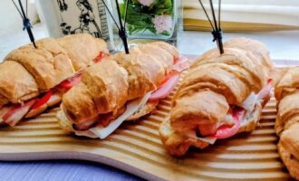 Готовые круассаны с ветчиной, беконом и сыром на тарелке