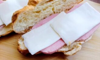 Плавленый сыр, уложенный поверх ветчины в круассане