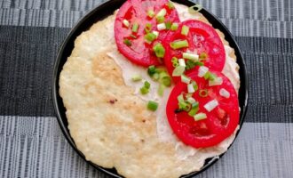 Куриный блинчик с помидорами и зеленью, сложенный пополам.