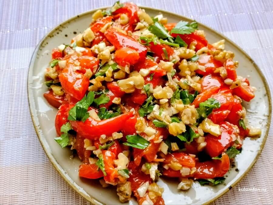 Закуска из запеченного болгарского перца с грецким орехом и зеленью на тарелке