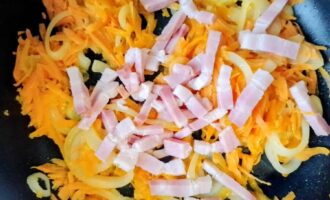 Грудинка, добавленная к луку и моркови на сковороде