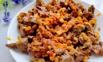 Готовая куриная печень с грудинкой на тарелке