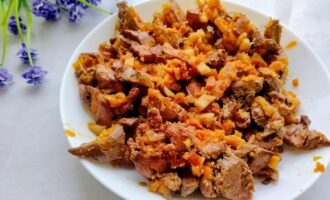 Готовая куриная печень с грудинкой на тарелке