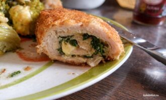 Готовые котлеты по-киевски в разрезе с сочной начинкой, подача с овощами