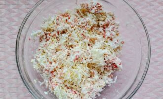 Сыр, крабовые палочки и отварное яйцо в миске перед смешиванием