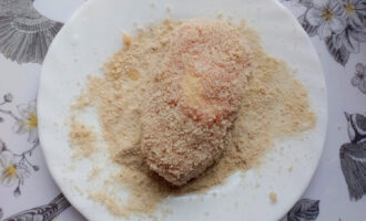Котлета, обвалянная в панировочных сухарях перед жаркой