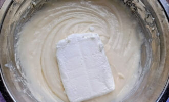 Творог, положенный в миску с тестом перед перемешиванием.
