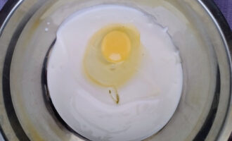 Яйцо, добавленное в миску с кефиром, вид сверху.