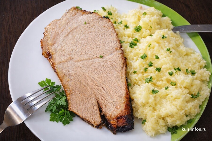 Свинина, запеченная в рукаве, с картофельным пюре на тарелке