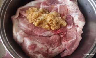 Сырая свинина с маринадом из лука и чеснока в металлической миске