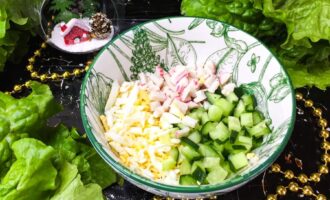 Миска с подготовленными ингредиентами: яйцо, крабовые палочки и огурец