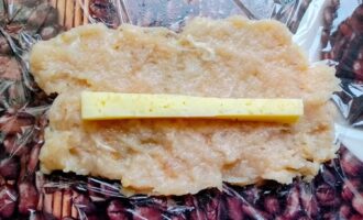 Кусочек сыра, выложенный в центр лепешки из куриного фарша