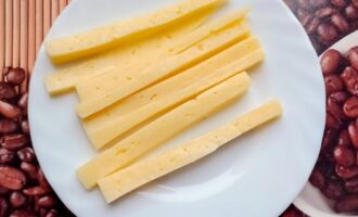 Нарезанный длинными брусками сыр для начинки куриных колбасок