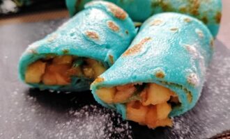 Блинчики с яблоком и корицей голубого цвета с сахарной пудрой