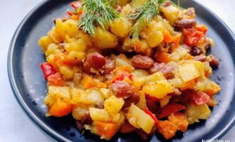 Картофель с фасолью и овощами на тарелке