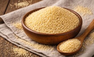 Кускус — сухая пшеничная крупа в деревянной миске на столе