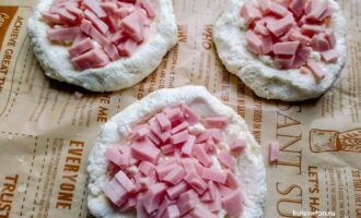 Мини-пиццы с нарезанной ветчиной поверх творожного сыра