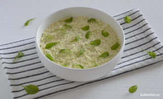 Готовый слоеный салат со скумбрией украшенный свежей зеленью