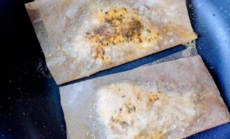 Куриные отбивные жарятся на сковороде в пергаменте